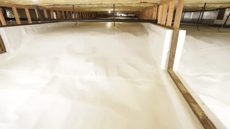 brightly lit crawlspace with white encapsulation liner and clean supports