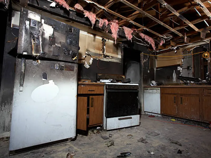 damaged kitchen fire charred walls exposed ceiling scattered debris